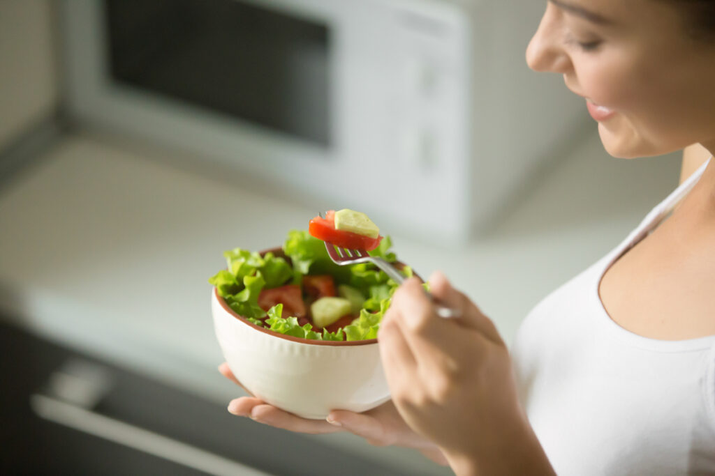 Woman eating a bowl of healthy food